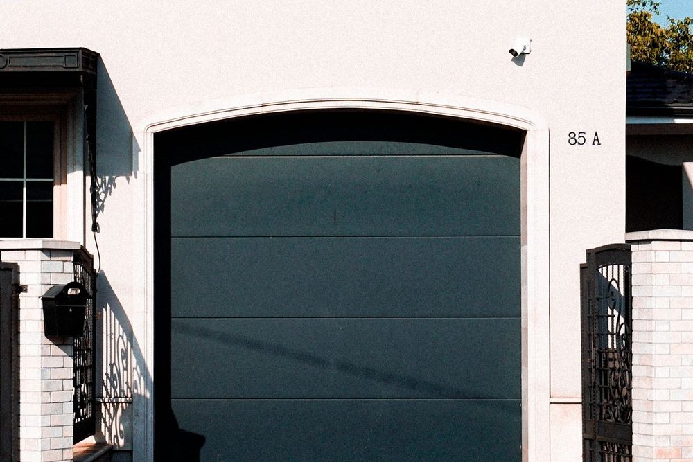Einfamilienhaus mit dunkelgrünem Sektionaltor in der Garage