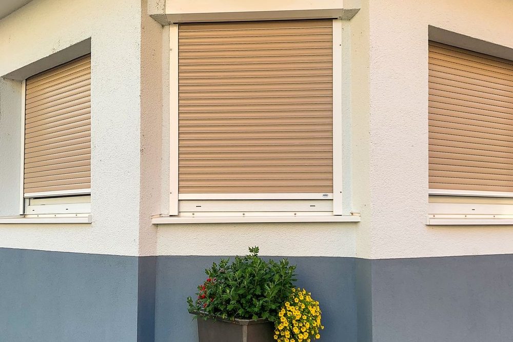 Fenster mit Rollläden an einer hellen Hausecke