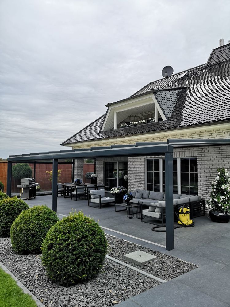 Terrassendach mit Natursteinterrasse und Sitzgruppe