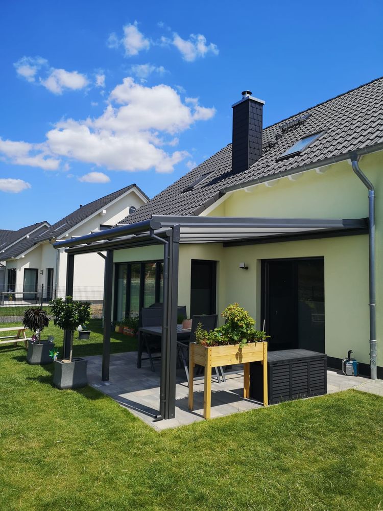 Terrassendach an einem Einfamilienhaus mit gelber Fassade