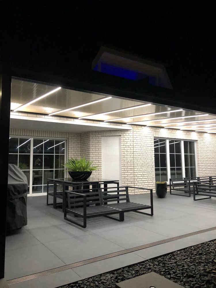 Beleuchtetes Terrassendach mit LED-Streifen in der Dämmerung